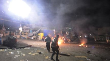 Policiers intervenant contre une barricade dressée par des partisans de Michel Martelly (AFP - Thony BELIZAIRE)