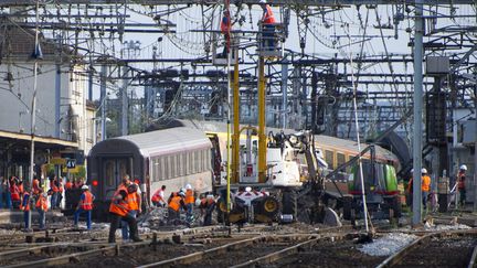 Les services de sécurité et de secours s'activent autour du train Corail qui a déraillé, dans la&nbsp;gare de Brétigny-sur-Orge (Essonne), le 13 juillet 2013. (MAXPPP)