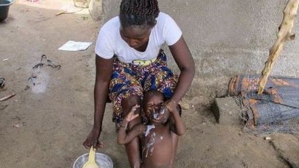 Gavage d'un bébé au Cameroun. (REINNIER KAZE / AFP)