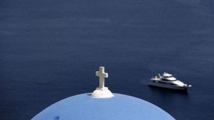 Un yacht navigue au large de l'île grecque de Santorin, le 1er juin 2015. Le ciel, le soleil et la mer... (Reuters - Cathal McNaughton)