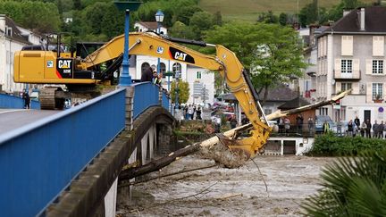 Bull-dozer &agrave; l'oeuvre pour nettoyer le village de Nay (Pyr&eacute;n&eacute;es-Atlantiques), d&eacute;vast&eacute; par les inondations. (DAVID LE DEODIC / AFP)