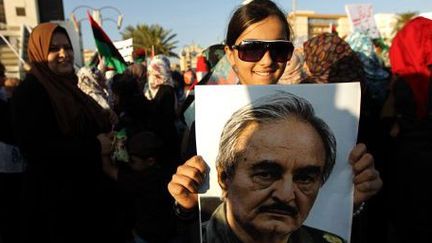 Une jeune Libyenne tient devant elle un portrait du général à la retraite Khalifa Haftar, lors d'un rassemblement en sa faveur fin mai 2014 à Benghazi, dans l'est de la Libye.  (AFP PHOTO / ABDULLAH DOMA)