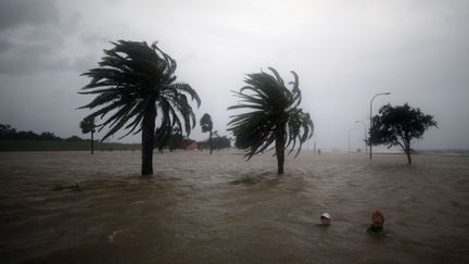 Deux Am&eacute;ricains nagent dans l'eau qui a d&eacute;bord&eacute; du Lac Pontchatrain, &agrave; la Nouvelle-Orl&eacute;ans (Louisiane,&nbsp;Etats-Unis) &agrave; l'approche de l'ouragan Isaac, le 28 ao&ucirc;t 2012. (CHRIS GRAYTHEN / GETTY IMAGES / AFP)