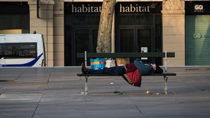 Un sans-abri dort sur un banc public à Paris, le 17 mars 2020 (photo d'illustration).&nbsp; (JOEL SAGET / AFP)