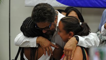 Le commandant des Farc, Ivan Marquez,&nbsp;embrasse des victimes du conflit armée entre la guérilla et le gouvernement colombien, le 24 août 2016 à La Havane (Cuba). (YAMIL LAGE / AFP)