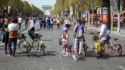 Une famille fait du vélo sur les Champs Elysées à Paris, le 16 septembre 2018. (MAXPPP)