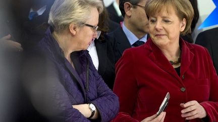 Angela Merkel montrant un message à une de ses ministres. (JOHANNES EISELE )