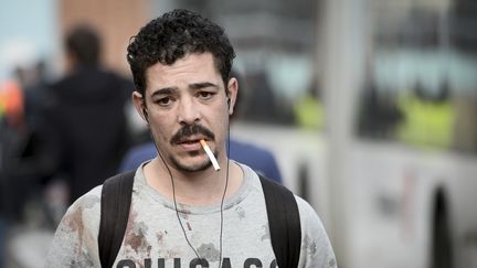 Un homme au pull tâché de sang quitte l'aéroport de Bruxelles à Zaventem après deux explosions, mardi 22 mars 2016. (DIRK WAEM / BELGA / AFP)