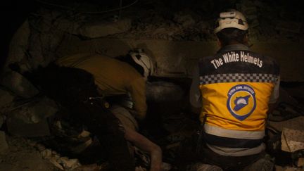 Des Casques blancs lors d'une opération de secours après un raid aérien, près d'Idlib (Syrie), le 7 juin 2018. (AHMET MIMAR / ANADOLU AGENCY / AFP)