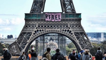 Des militants du mouvement écologiste Extinction Rebellion&nbsp;déploient une banderole au premier étage de la tour Eiffel à Paris, le 11 octobre 2020. (STEPHANE DE SAKUTIN / AFP)