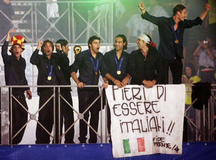 Les joueurs italiens célèbrent la victoire leur équipe lors de la Coupe du monde en Allemagne, avec une banderole "Fiers d'être italiens", le 10 juillet 2006 à Rome. (CHRIS HELGREN / REUTERS)