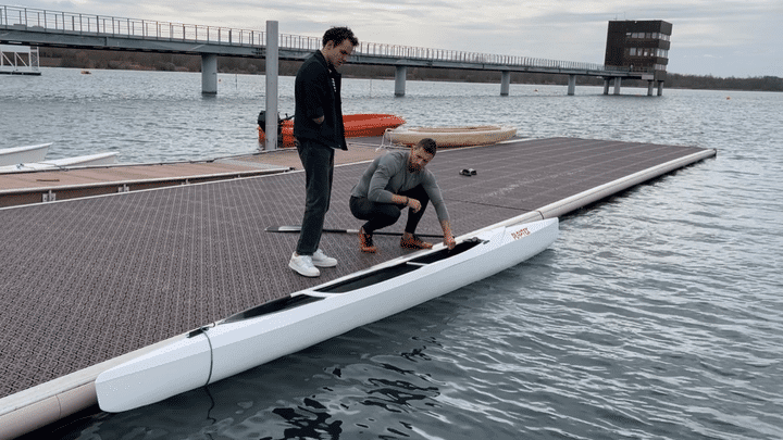 Adrien Bart présente son canoë à Théo Curin, sur l'un des pontons qui serviront aux épreuves olympiques, pour les Jeux de Paris 2024. (FABRICE RIGOBERT / FRANCEINFO)