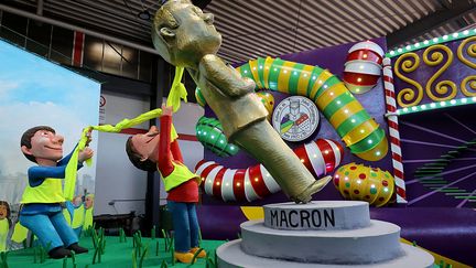 Un char du carnaval de Cologne représente une statue d'Emmanuel Macron déboulonnée par des "gilets jaunes", le 26 février 2019. (OLIVER BERG / DPA / AFP)