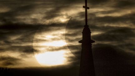 Eclipse solaire partielle aper&ccedil;ue entre les nuages au-dessus de la basilique du Sacr&eacute; Coeur de l'universit&eacute; de Notre Dame (Indiana, Etats-Unis), le 23 octobre 2014. (ROBERT FRANKLIN / AP / SIPA)