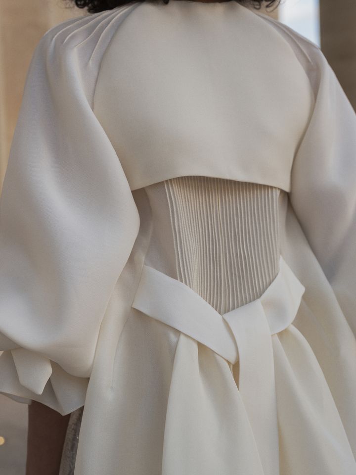 La mannequin Zuleica Eliana porte une blouse-trench nervuré en gaze craie de la collection couture printemps-été 2022 de Christophe Josse au Panthéon à Paris, janvier 2022 (Cécile Bortoletti)