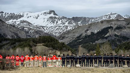 Les secouristes et les gendarmes se recueillent devant le m&eacute;morial pour les victimes du crash de l'A320, le 28 mars 2015 au Vernet (Alpes-de-Haute-Provence). (JEFF PACHOUD / AFP)