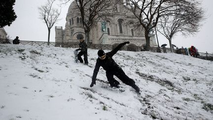 Des personnes profitent de l'épisode neigeux pour faire du ski et du snowboard sur la butte Montmartre, à Paris. (PHILIPPE WOJAZER / REUTERS)