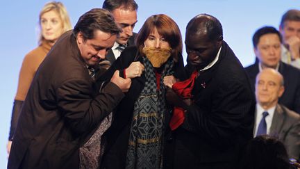 Une membre du collectif f&eacute;ministe La Barbe est &eacute;vacu&eacute;e de la tribune lors de la convention UMP &agrave; Paris (15e), le 6 d&eacute;cembre 2011. (CHARLES PLATIAU / REUTERS)