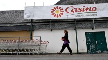 Une cliente à l'entrée d'un supermarché Casino à Ploubalay, dans les Côtes-d'Armor, le 5 juillet 2023. (DAMIEN MEYER / AFP)