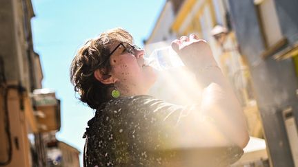 Une femme s'hydrate dans les rues de Cours (Rhône), le 16 juillet 2022, alors que la France traverse un épisode de chaleur. (ADRIEN FILLON / HANS LUCAS)