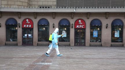 Un inspecteur sanitaire désinfecte&nbsp;une rue commerçante à Pékin (Chine), le 5 février 2020.&nbsp; (KOKI KATAOKA / YOMIURI / AFP)