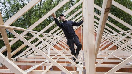 Un artisan charpentier travaille sur le chantier d'une maison en avril 2020. (VINCENT ISORE / MAXPPP)