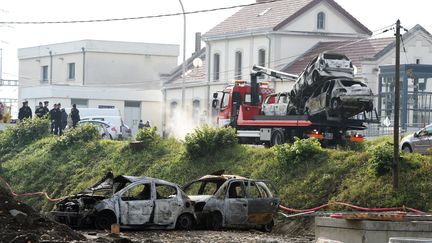 Un camion &eacute;vacue les voitures br&ucirc;l&eacute;es, le 21 octobre 2015 &agrave; Moirans (Is&egrave;re). (PHILIPPE DESMAZES / AFP)