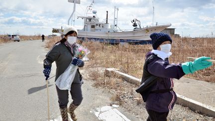 Des proches de victimes du tsunami de Fukushima se rendent sur les sites d'anciennes maisons, &agrave; Namie (Japon), pr&egrave;s du complexe nucl&eacute;aire endommag&eacute; de Fukushima,&nbsp;le 11 mars 2014.&nbsp; (YOSHIKAZU TSUNO / AFP)