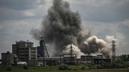 De la fumée s'élève après une frappe sur une usine située à&nbsp;Soledar, dans la région du Donbass, dans l'est de l'Ukraine, le 24 mai 2022. (ARIS MESSINIS / AFP)