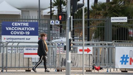 Une femme marche le long d'un centre de vaccination dans la ville de Nice, dans le sud de la France, le 18 avril 2021. (VALERY HACHE / AFP)