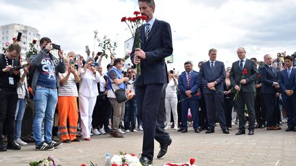 Accompagné d'autres diplomates, l'ambassadeur de France en Biélorussie, Didier Canesse, dépose un bouquet, le 13 août 2020, à Minsk, à l'emplacement de la mort d'un manifestant, trois jours plus tôt. (SERGEI GAPON / AFP)