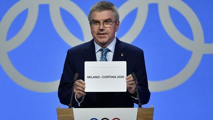 Thomas Bach, le président du Comité international olympique, dévoile à Lausanne, le 24 juin, le nom de la ville qui accueillera les JO d'hiver 2026. (FABRICE COFFRINI / AFP)