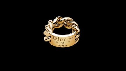 Dior Joaillerie a rendu plus d’une fois hommage à la couture et à la maison qui l’abrite. La bague Gourmette en est l’exemple le plus évocateur. Telle l’étiquette cousue au revers des vêtements Christian Dior, elle montre ce qui d’ordinaire est caché : la marque, son numéro individuel, son métrique, les poinçons et le titrage d’or.
 (Christian Dior.)