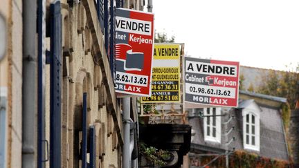 Des panneaux "À vendre" aux fenêtres d'appartements à Morlaix (Finistère). (MAXPPP)