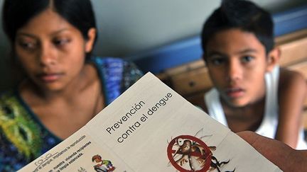 Dans une clinique de San Jose, des guides d’information sont fournis par le personnel de santé à la population. ( AFP PHOTO/Hector RETAMAL  )