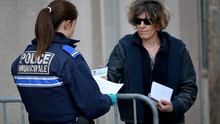 Une policière contrôle une femme durant le confinement à Montbrison (Loire), le 21 mars 2020. Photo d'illustration. (REMY PERRIN / MAXPPP)