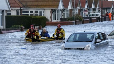 Des secouristes &eacute;vacuent des r&eacute;sidents &agrave;&nbsp;Rhyl, station baln&eacute;aire dans le nord du Pays de Galles, le 5 d&eacute;cembre 2013.&nbsp;A l'aide d'un bateau gonflable, ils viennent en aide aux victimes de la temp&ecirc;te. (PHIL NOBLE / REUTERS)