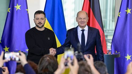 Le chancelier allemand Olaf Scholz (à droite) et le président ukrainien Volodymyr Zelensky, lors d'une conférence de presse à Berlin, le 11 octobre 2024. (JOHN MACDOUGALL / AFP)