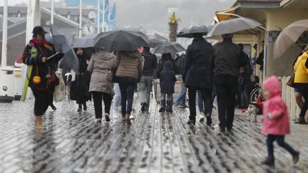 Des gens marchent sous la pluie à Deauville, en Normandie, le 30 avril 2017. (LUDOVIC MARIN / AFP)