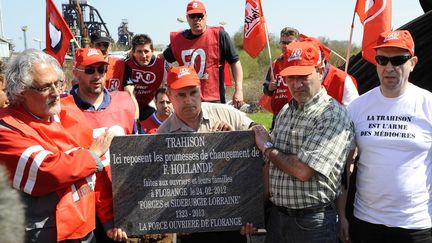 Les employ&eacute;s de Florange et syndicalistes de FO, avec la plaque d&eacute;non&ccedil;ant la "trahison" de Fran&ccedil;ois Hollande, le 24 avril 2013. (JEAN-CHRISTOPHE VERHAEGEN / AFP)