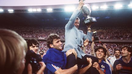 Michel Hidalgo, porté par ses joueurs de l'équipe de France lors de leur victoire au Parc des princes de l'Euro de football à Paris, le 27 juin 1984. (AFP)