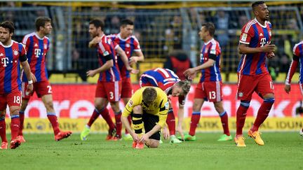 Jakub Blaszczykowski refait ses lacets pendant que les joueurs du Bayern célèbrent leur but (JONAS G?TTLER / DPA)