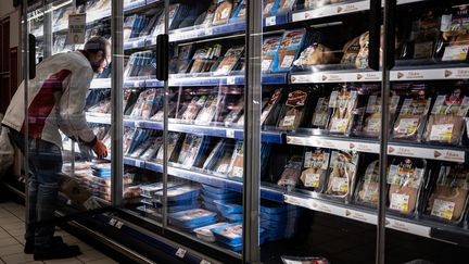 Un employé remplit le rayon viandes d'un supermarché bordelais. (PHILIPPE LOPEZ / AFP)