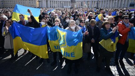 Des fidèles portent des drapeaux ukrainiens alors que le pape François récite la prière de l'Angélus, le dimanche 6 mars 2022, au Vatican. (FILIPPO MONTEFORTE / AFP)