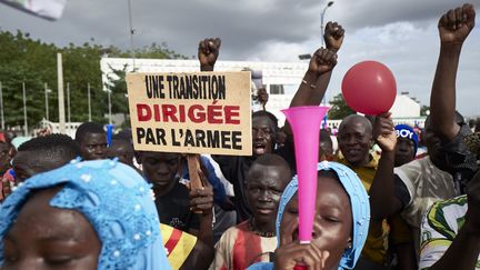 Un homme tient une pancarte indiquant "Une transition dirigée par l'armée"&nbsp;lors d'un rassemblement des partisans de la junte malienne sur la place de l'Indépendance à Bamako, le 8 septembre 2020. (MICHELE CATTANI / AFP)