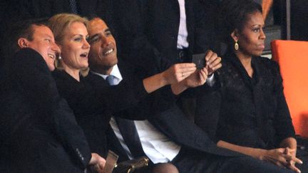 Le Premier ministre britannique David Cameron, son homologue danoise&nbsp;Helle Thorning Schmidt et le pr&eacute;sident am&eacute;ricain Barack Obama se prennent en photo, le 10 d&eacute;cembre 2013, lors de la c&eacute;r&eacute;monie d'hommage &agrave; Nelson Mandela au stade Soccer City de&nbsp;Johannesburg (Afrique du Sud). (ROBERTO SCHMIDT / AFP)