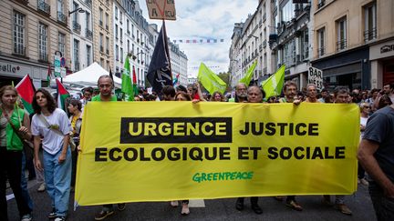 Des manifestants tiennent une banderole de Greenpeace, le 7 septembre 2024 à Paris. (MILLA MORISSON / HANS LUCAS / AFP)