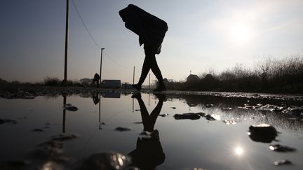 Un migrant porte sa valise, avant de quitter le campement de Calais, mardi 25 octobre 2016. (NEIL HALL / REUTERS)