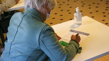 Une femme remplit un&nbsp;questionnaire avant de se faire vacciner contre le Covid-19, à Valence (Drôme), le 3 mai 2021. (NICOLAS GUYONNET / AFP)