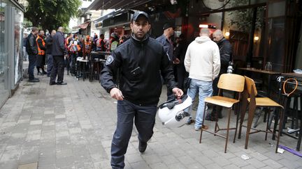 Un policier israélien court après la fusillade qui a éclaté dans un bar du centre de Tel-Aviv (Israël), le 1er janvier 2016.&nbsp; (NIR ELIAS / REUTERS)